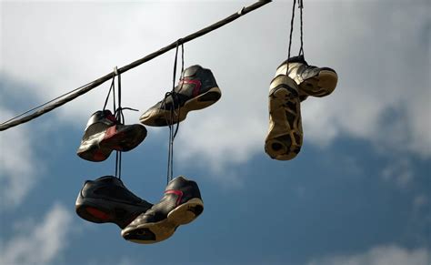 why do people throw shoes on power lines.